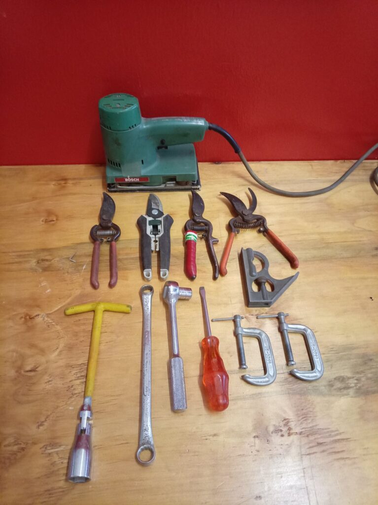 Bosch orbital sander (used, untested) with assorted hand tools — pruners, wrenches, screwdriver, C‑clamps