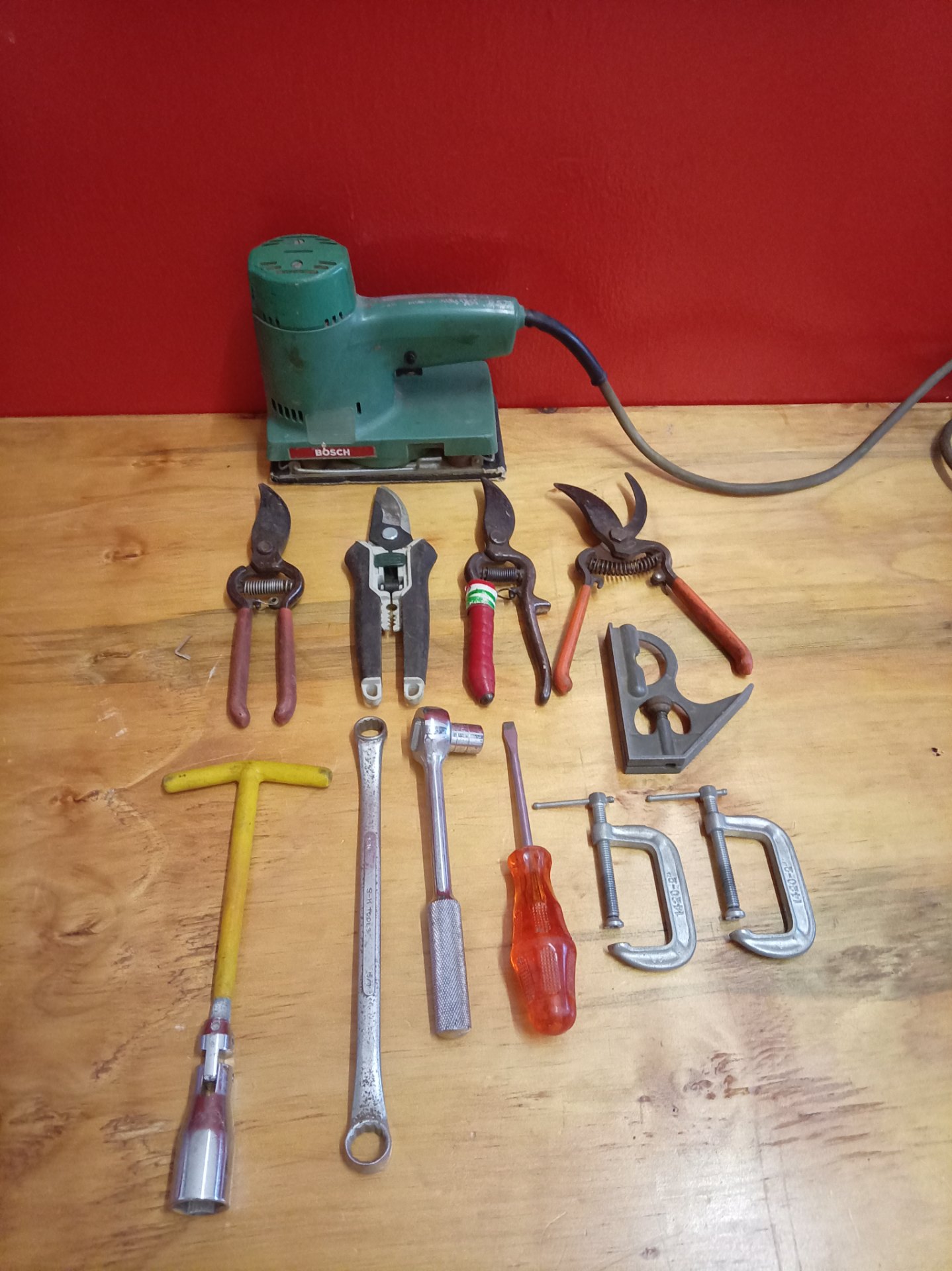 Bosch orbital sander (used, untested) with assorted hand tools — pruners, wrenches, screwdriver, C‑clamps