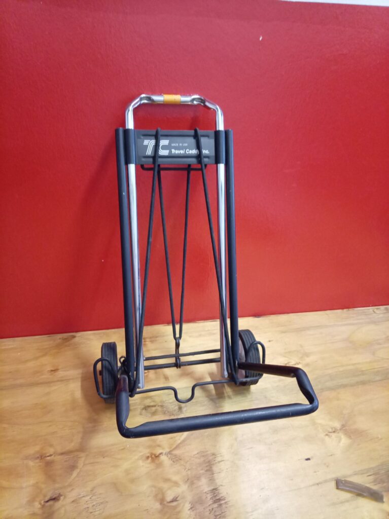 Travel Caddy folding luggage trolley — Travel Caddy Inc label, folds & locks, wheels & bungee straps