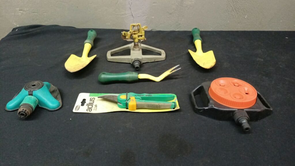 7‑piece garden hand tools & sprinkler heads lot — Adlus snips (packaged), 2 trowels, weeder + 3 sprinkler attachments