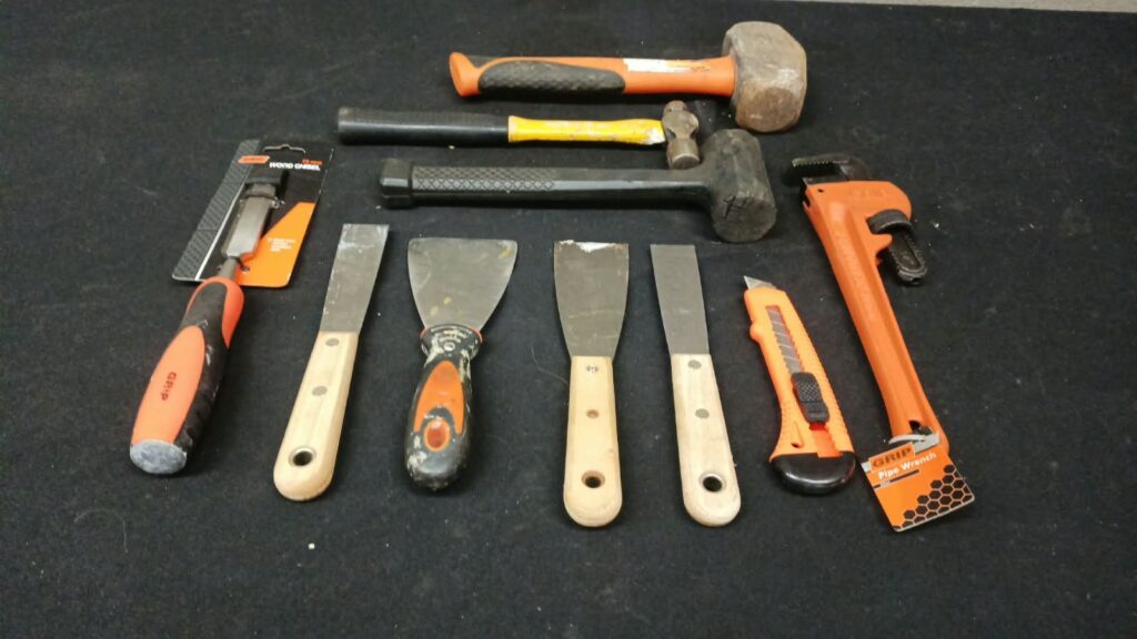 Mixed hand tool lot — 10-piece (hammers, mallet, scrapers, sealed 19mm chisel, GRIP 12″ / 300mm pipe wrench, utility knife)