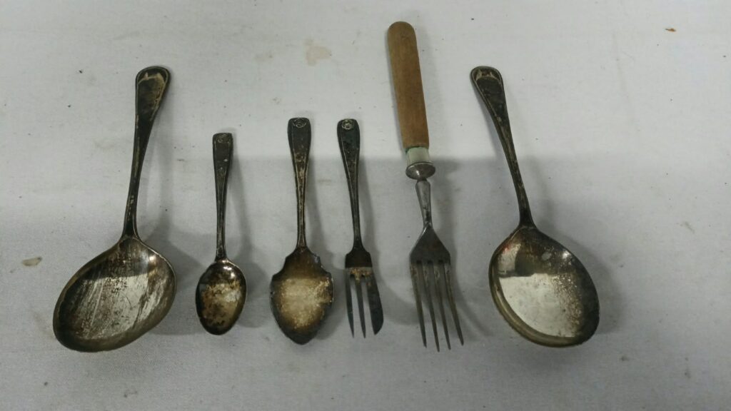 Mixed lot of 6 small 800/900 cutlery pieces — assorted spoons and forks, heavy tarnish and plating loss