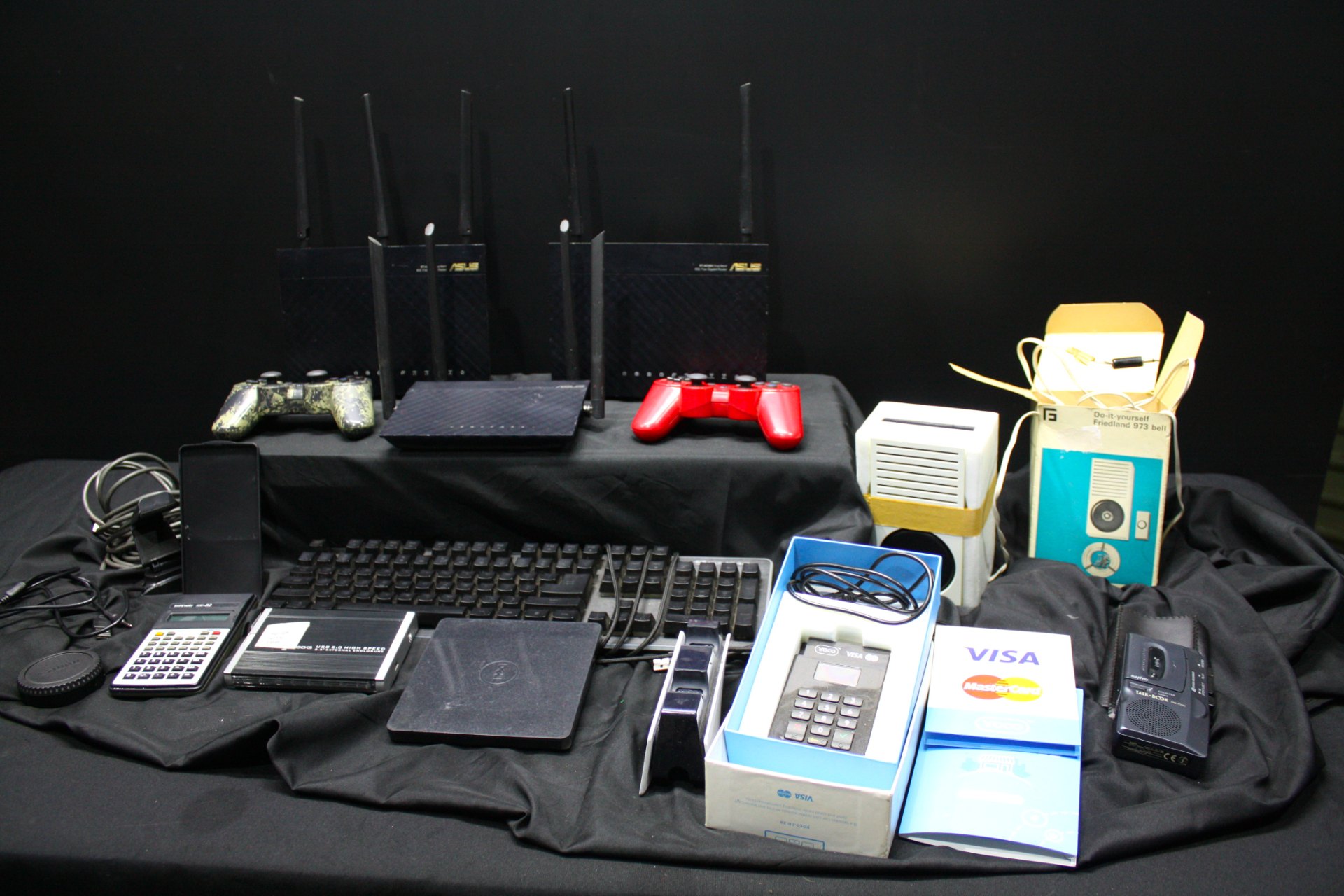 Mixed lot: ASUS routers (4), YOCO card terminal (boxed), controllers, keyboard, Sanyo Talk-Box & assorted accessories — Untested