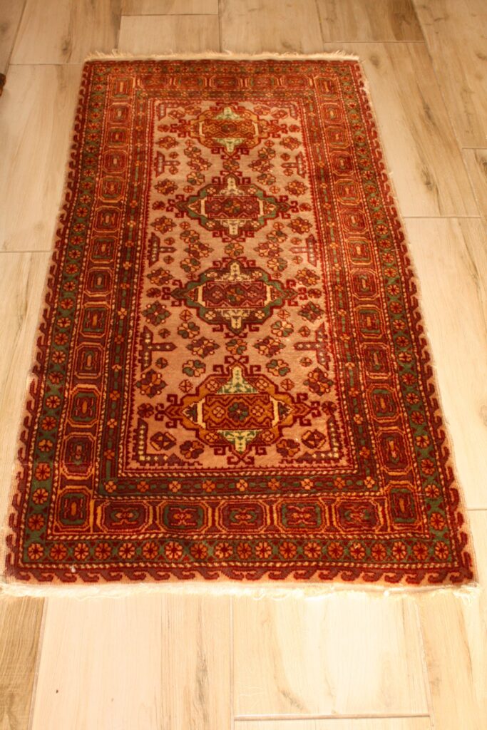 Oriental-style decorative runner — red/green/beige, labelled ‘AL 1130’ (approx. 125 × 200 cm)