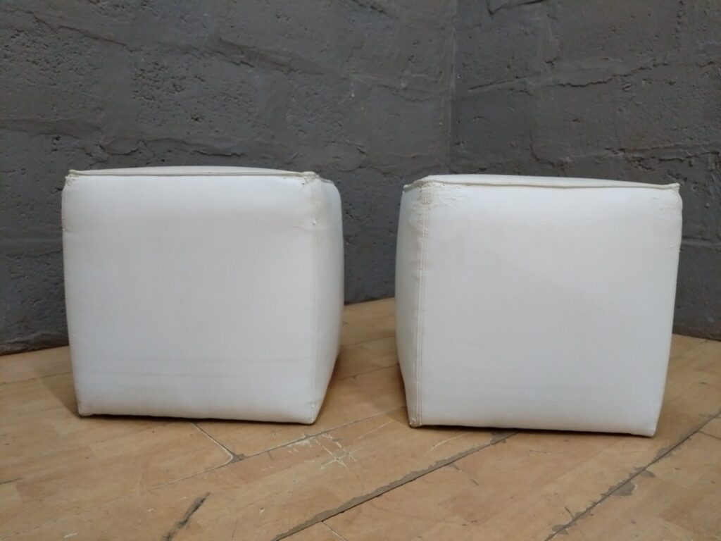 Pair of white cube ottomans / footstools – faux leather, heavy surface wear