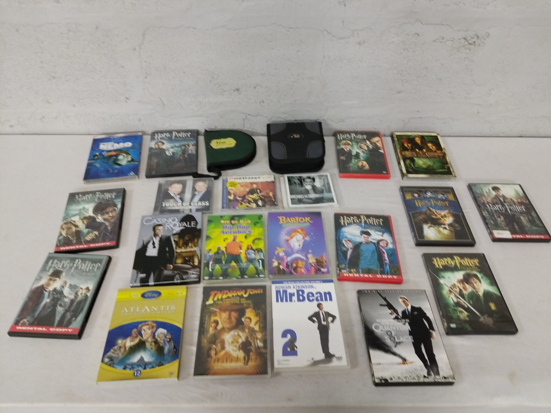 Lot of 21 DVDs & CDs — Harry Potter, Finding Nemo, Casino Royale, Pirates, James Bond + music CDs — tested, cases worn