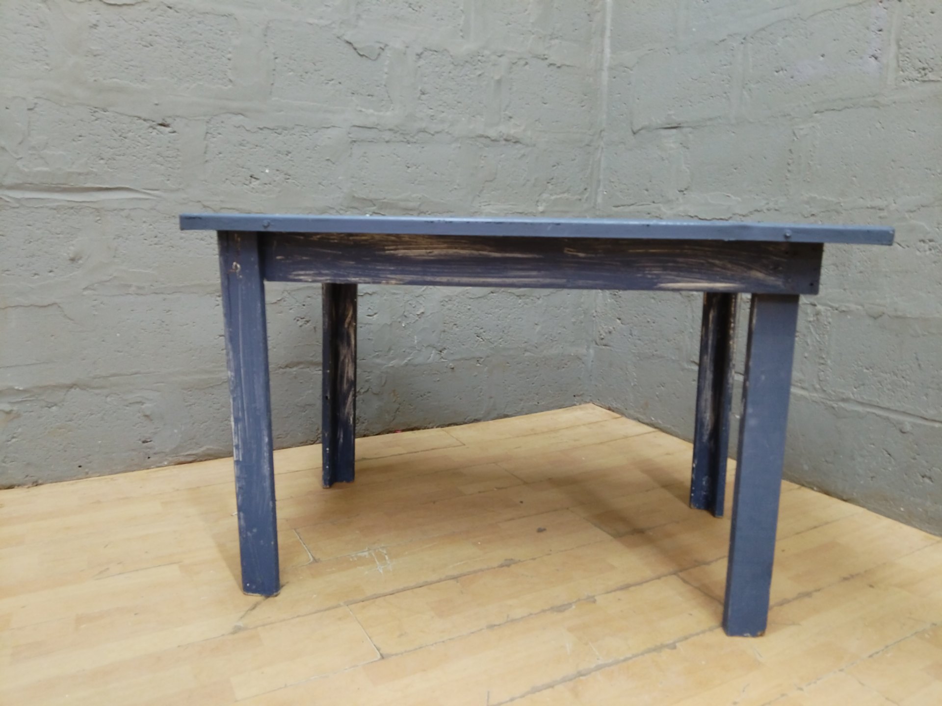 Small painted wooden table / bench 117 x 77 x 76 cm — paint-splattered top, cracked leg (needs repair)