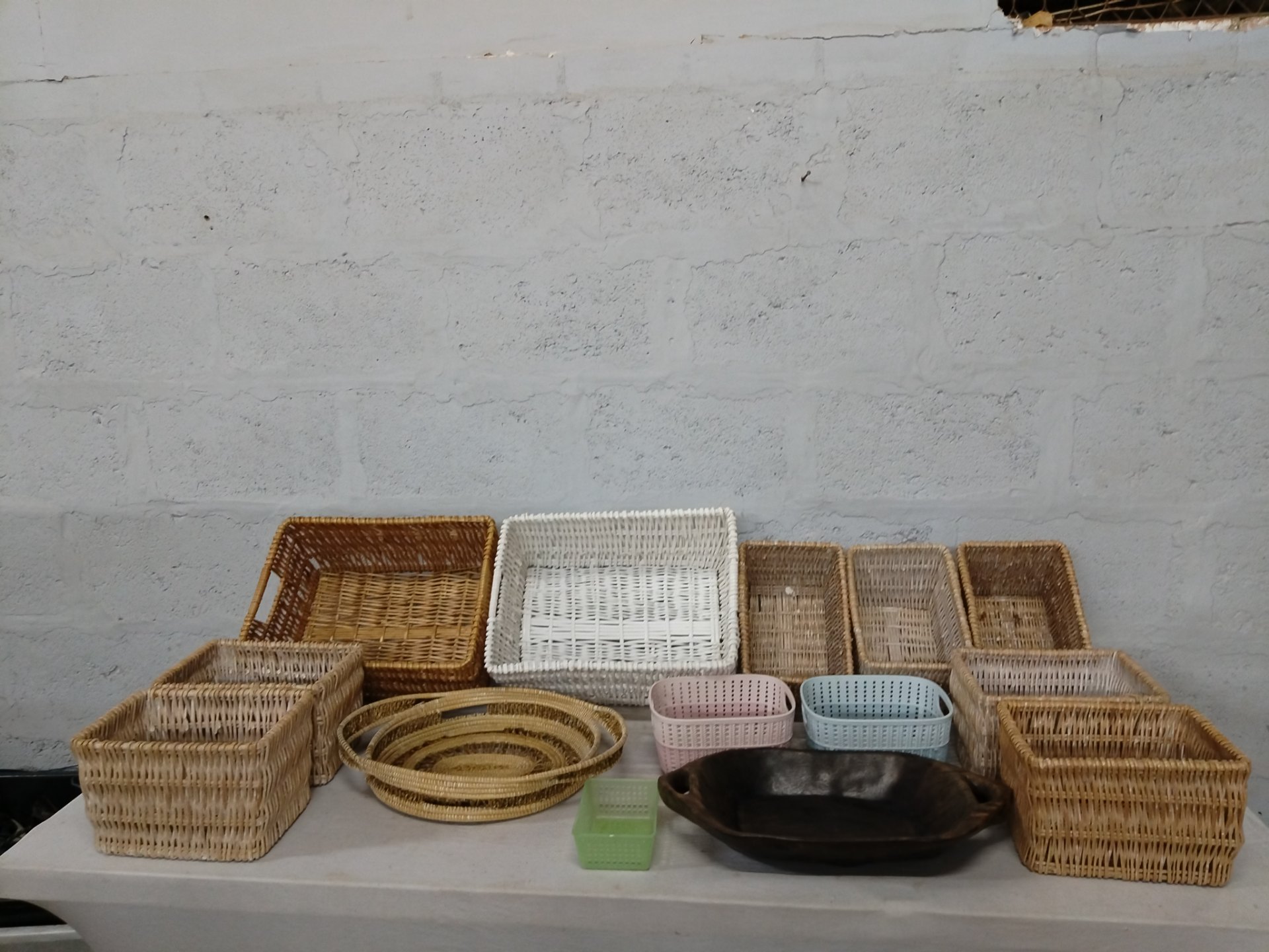 Mixed lot of 16 woven baskets, trays, plastic baskets and carved wooden bowl — used display / storage set