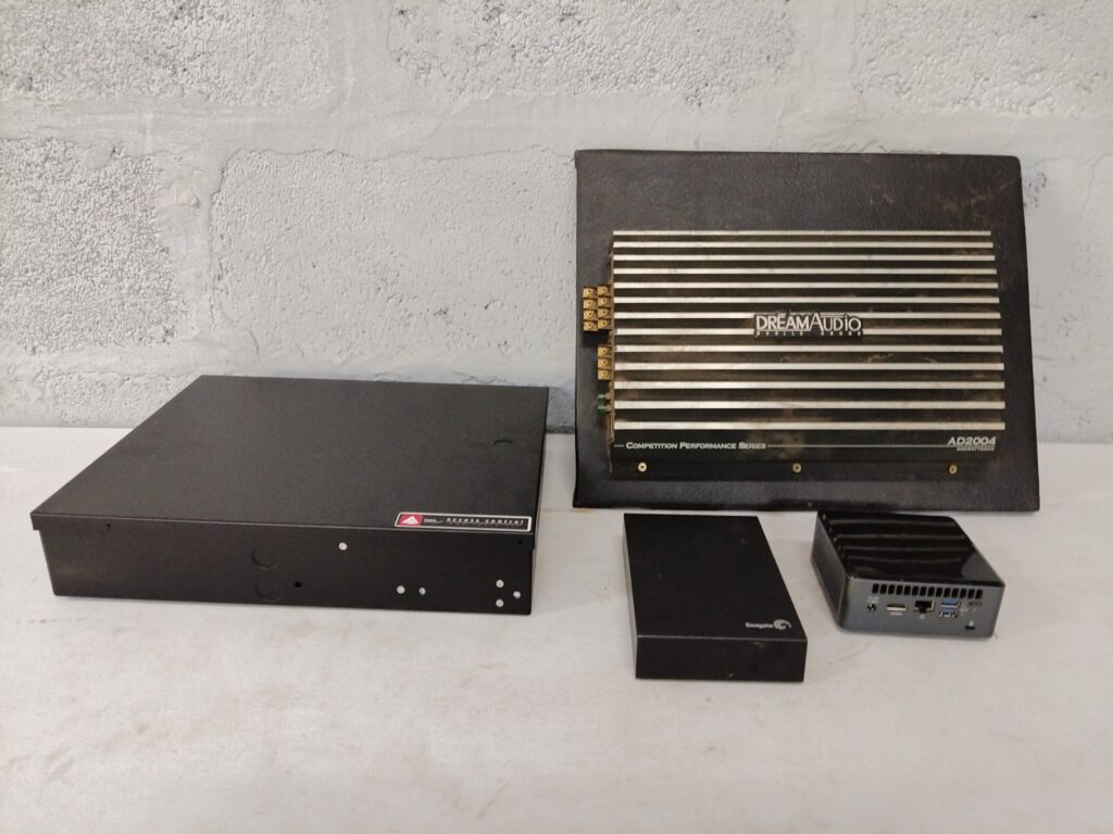 Mixed electronics lot: DreamAudio AD2004 car amplifier + Impro access-control enclosure (cluster controller + PSU) + Seagate external HDD enclosure + mini‑PC