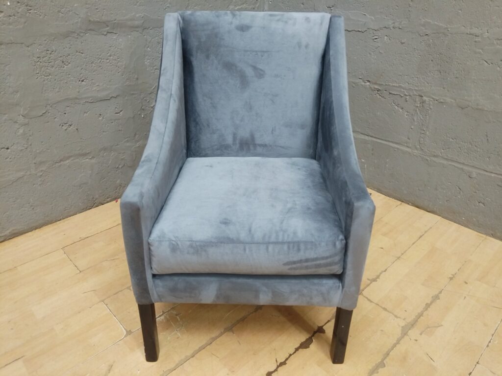 Grey velvet-look accent armchair — modern shape, tapered wooden legs, visible nap shading & light staining
