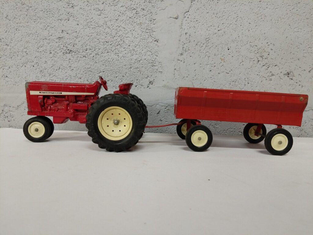 Red metal International tractor toy with detachable ERTL trailer — used, collectible display piece