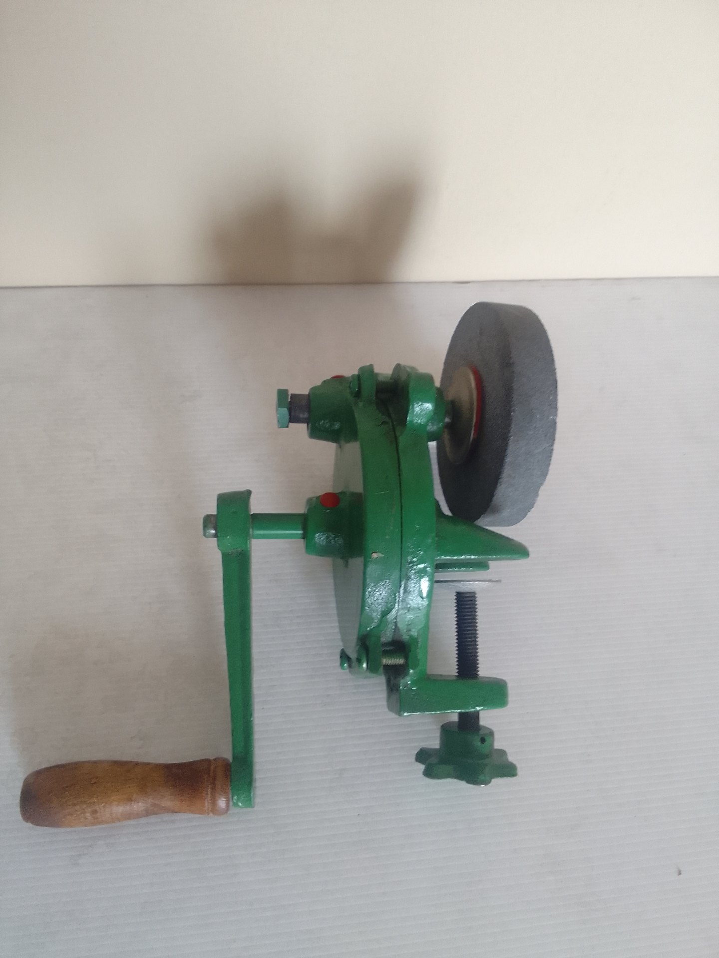Hand‑cranked clamp‑on bench grinder / sharpening wheel — green, used, wheel chipped