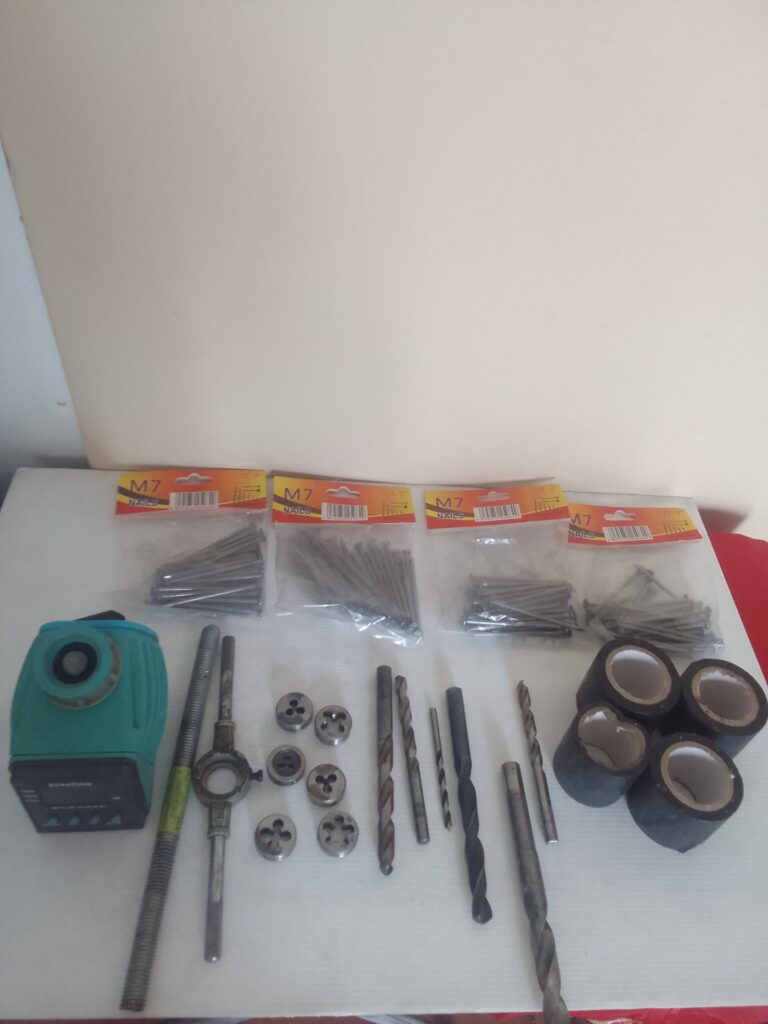 Assorted workshop hardware lot — drill bits, dies & die-stock, threaded rods, M7 nails and tape (used, visible surface rust)