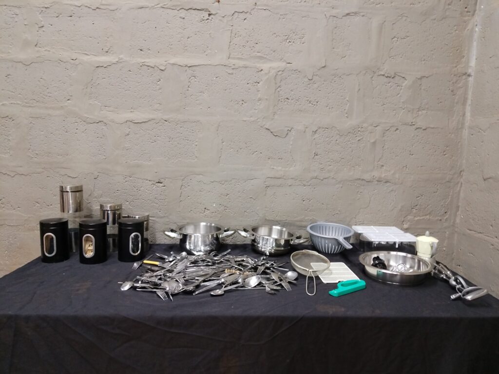 Bulk mixed kitchenware lot — approx. 80 pieces: loose cutlery, 2 stainless pots (no lids), canisters & small gadgets, used