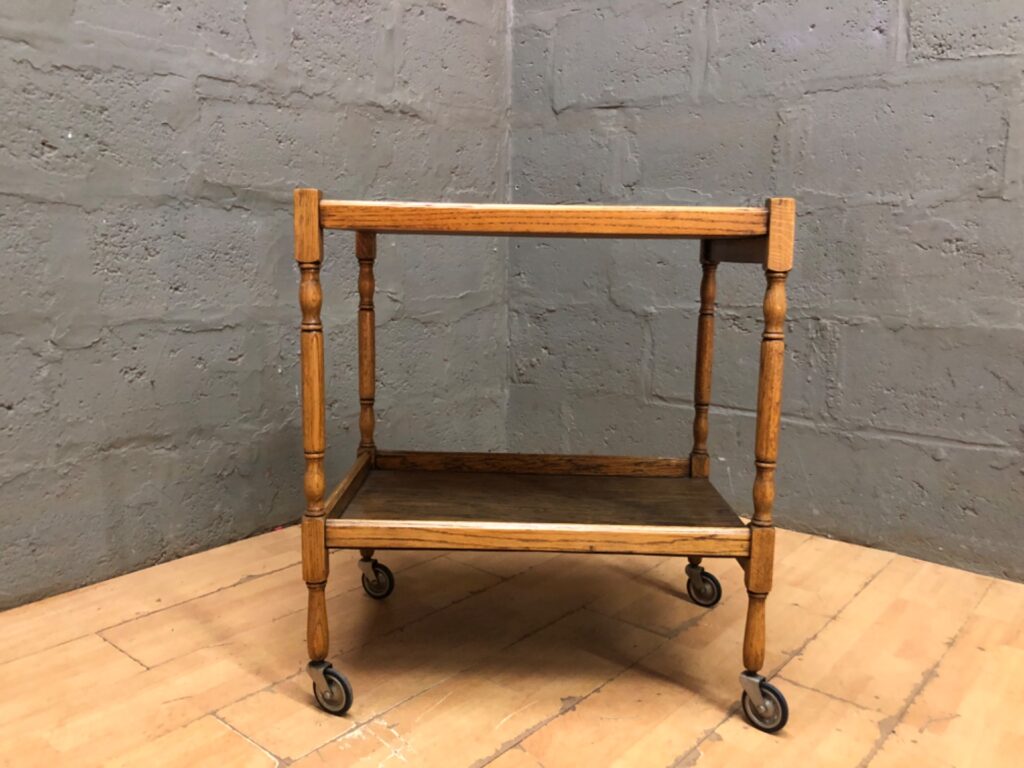 Two-tier wooden trolley on castors — oak-colour finish, turned legs (45 × 68 × 77 cm)