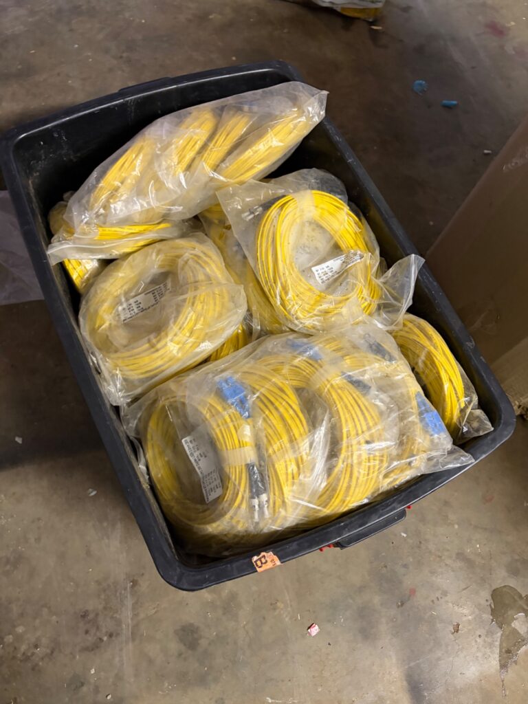 Bulk lot of yellow singlemode fibre patch cables — mixed sealed bundles in tub (blue/silver connectors)