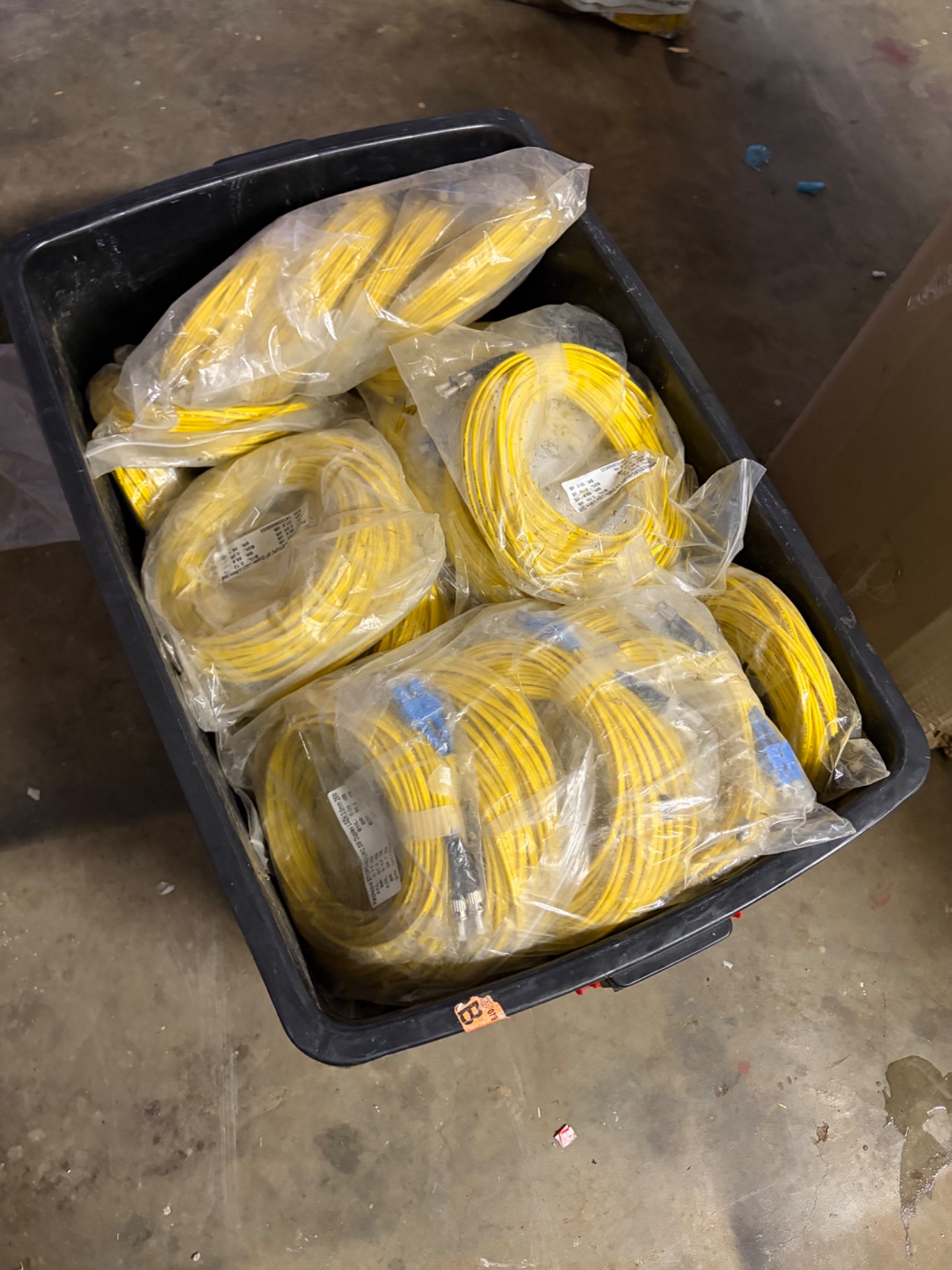 Bulk lot of yellow singlemode fibre patch cables — mixed sealed bundles in tub (blue/silver connectors)