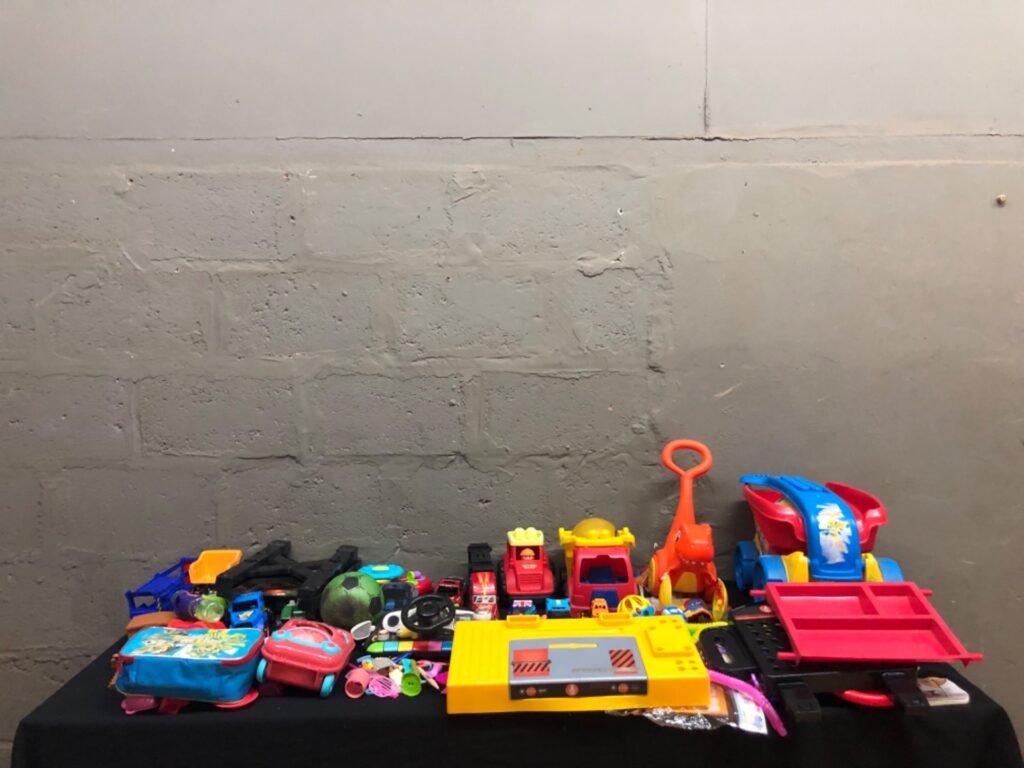Bulk mixed kids toys — assorted cars, ride-on, playsets, Paw Patrol bag (used)