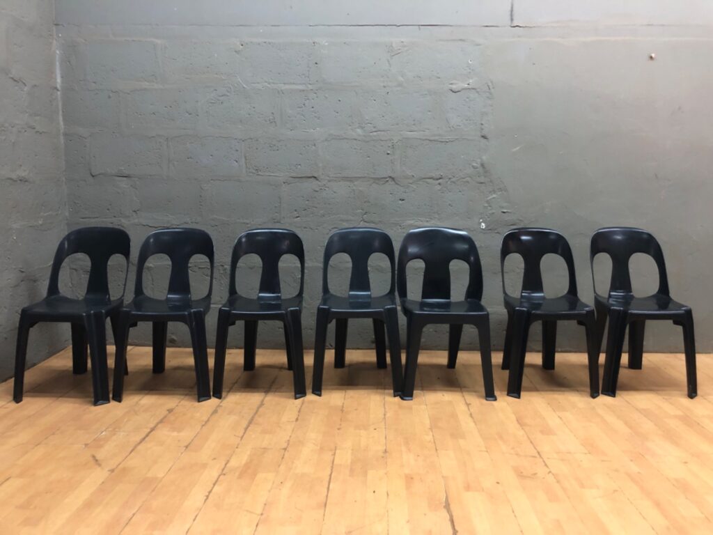 Lot of 7 Black Moulded Plastic Stacking Chairs — Used, scuffs & one cracked leg