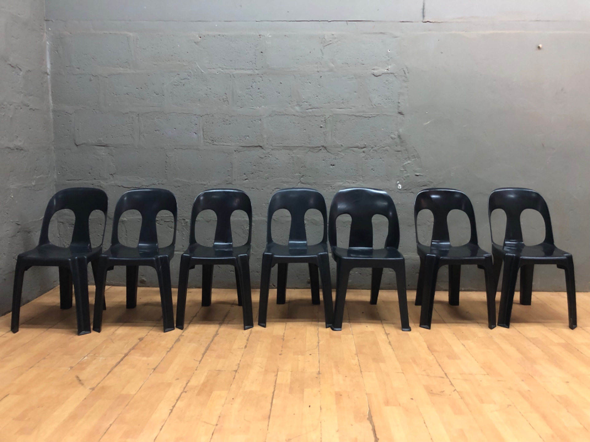 Lot of 7 Black Moulded Plastic Stacking Chairs — Used, scuffs & one cracked leg