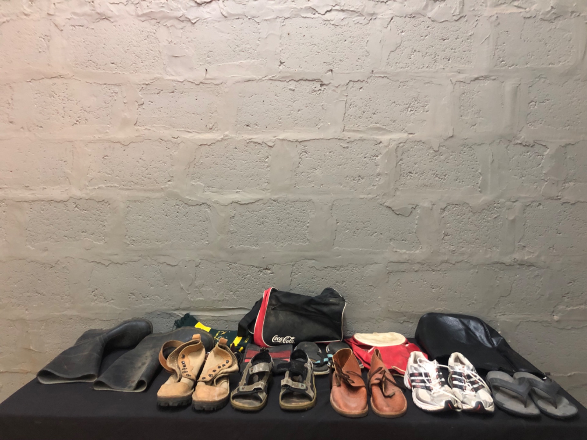 Mixed lot of used footwear & small bags — 7 pairs, Coca‑Cola bag, varied sizes, used condition