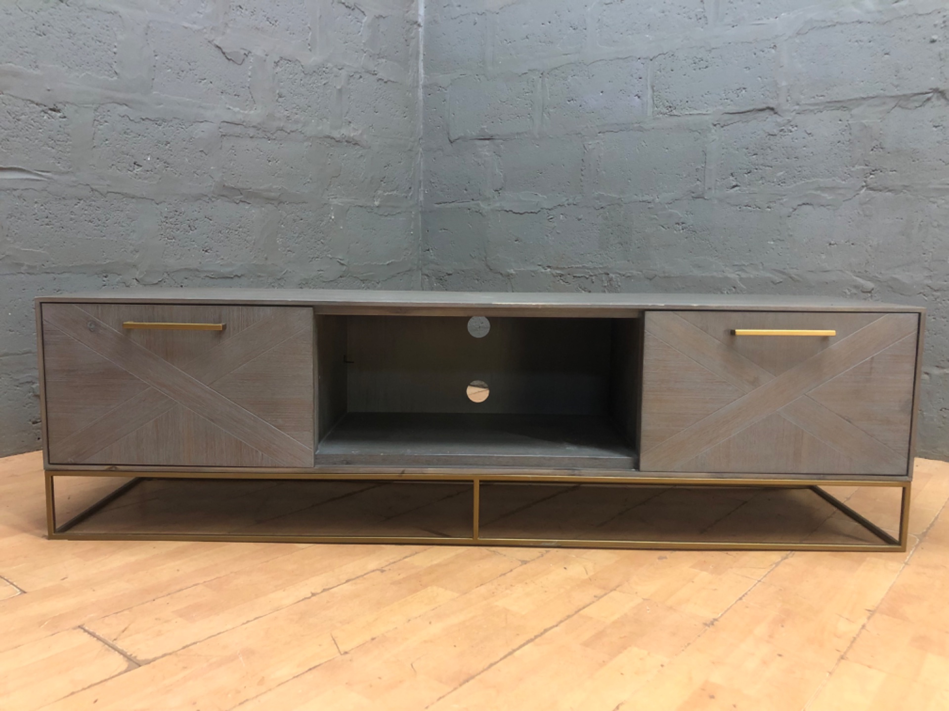 Low‑profile wooden TV / media console with metal base and rear cable holes