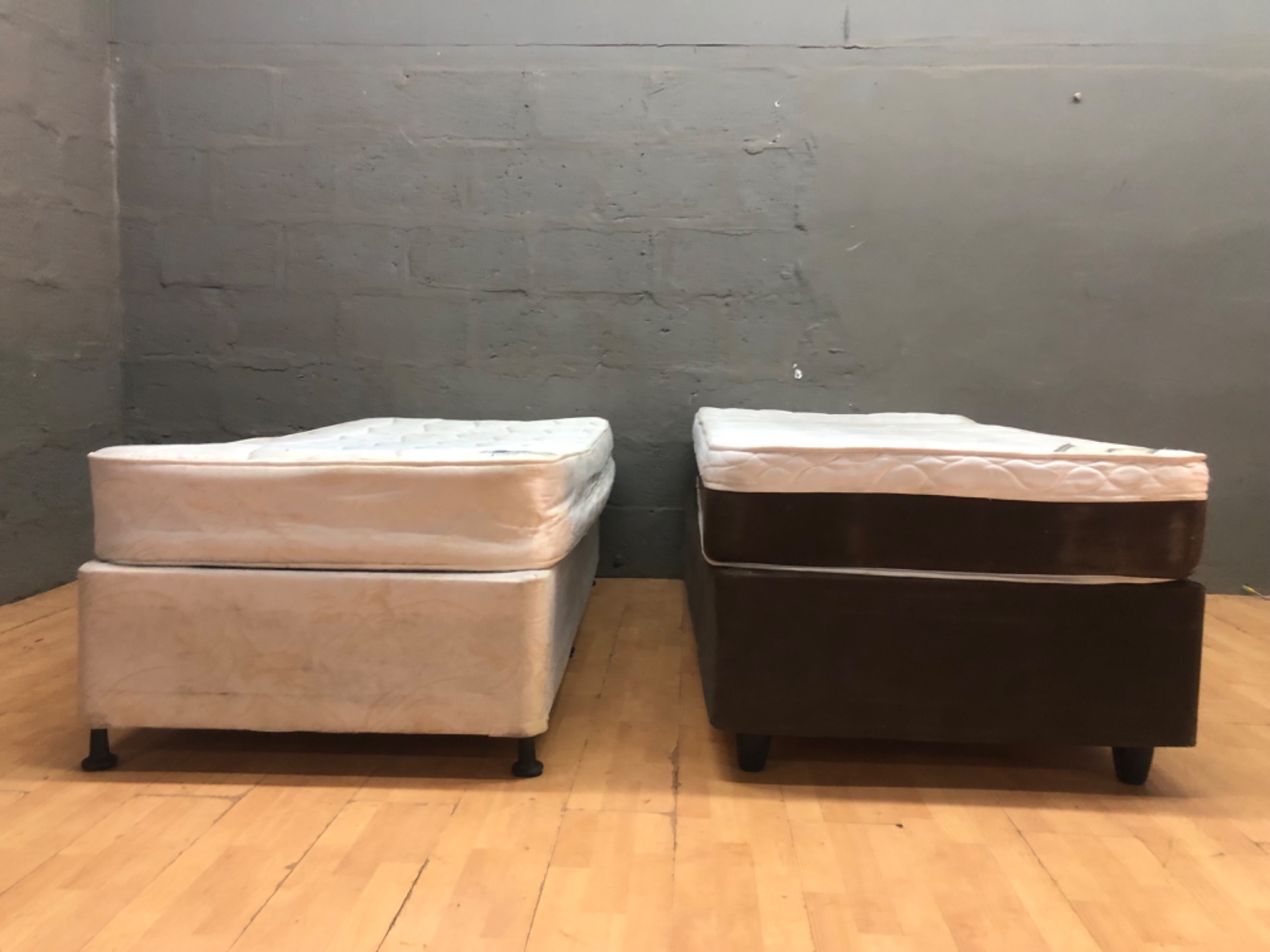 Pair of single mattresses on divan bases (used) — Posture Plush / Infinity labels, visible staining