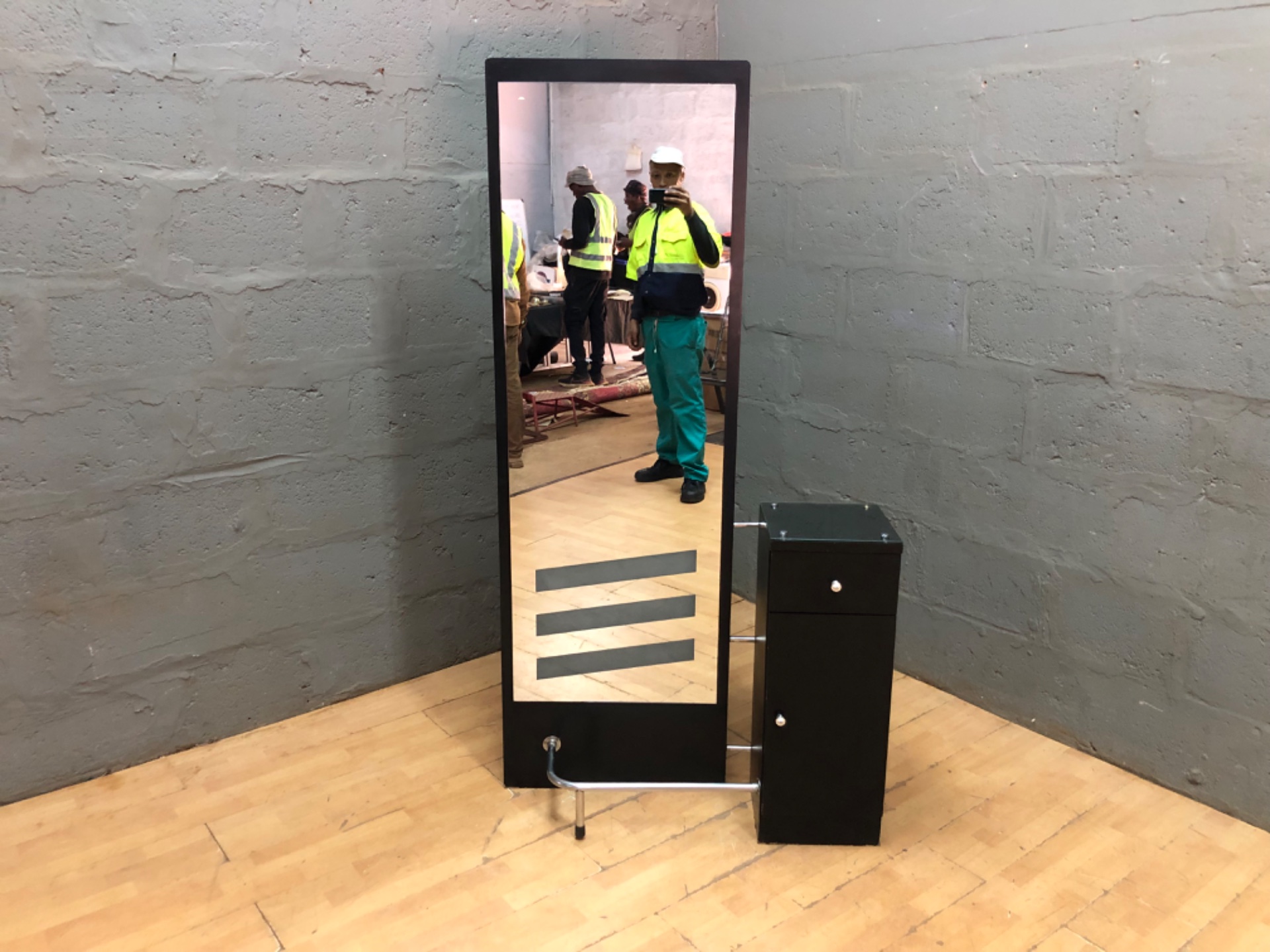 Freestanding salon-style full-length mirror with attached storage cabinet and glass top shelf