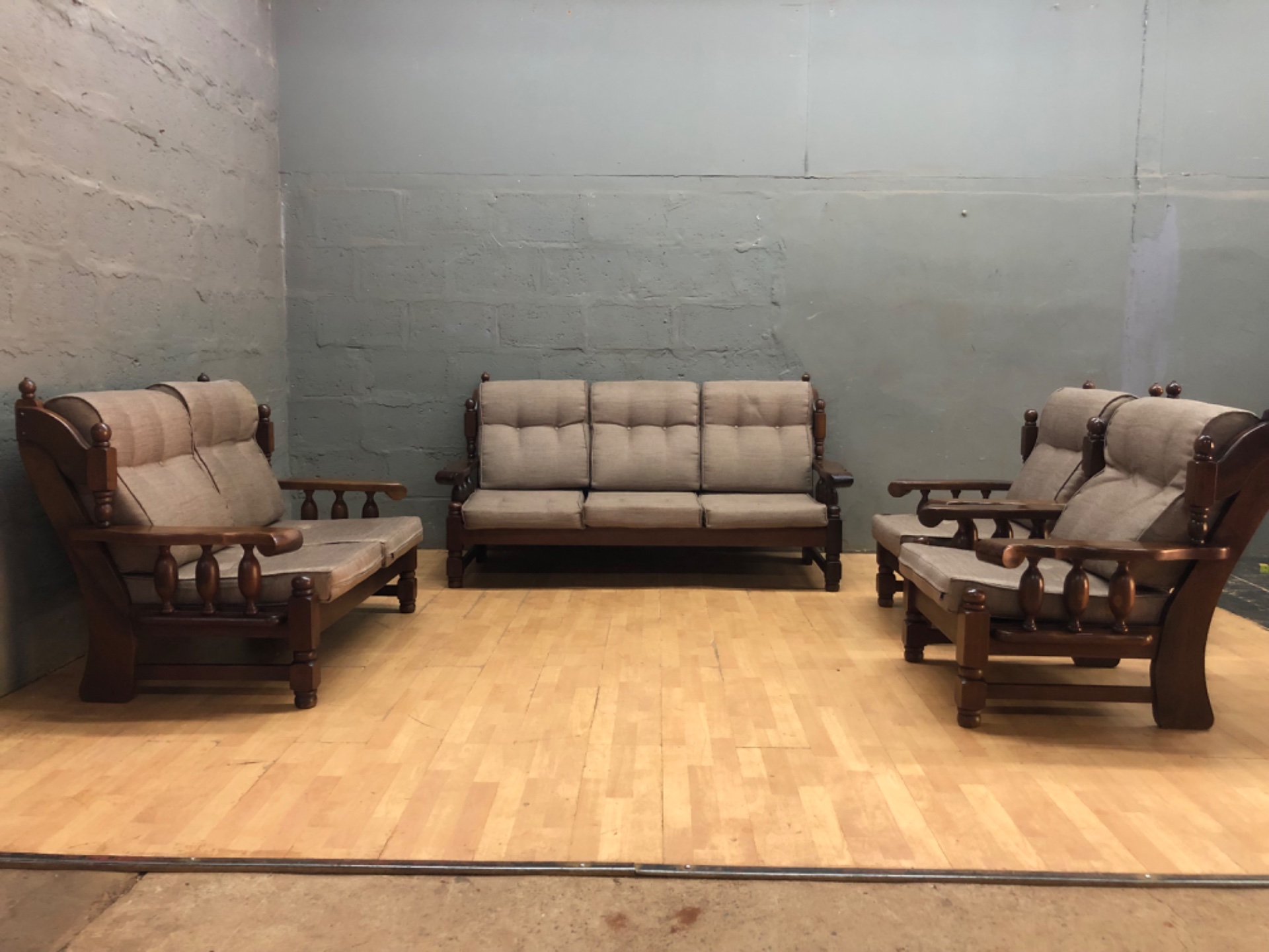 4‑piece solid timber living room suite — 3‑seater + 2 armchairs + matching piece (beige tufted cushions, visible wear)