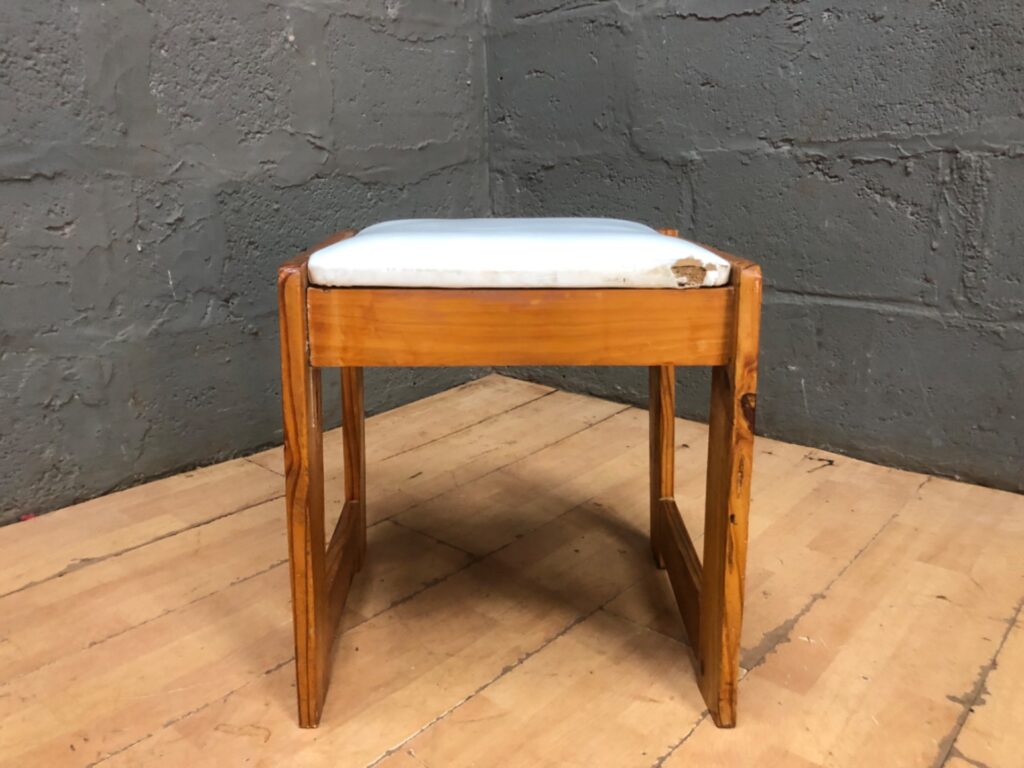 Small wooden stool / piano bench with padded seat — solid frame, worn white vinyl