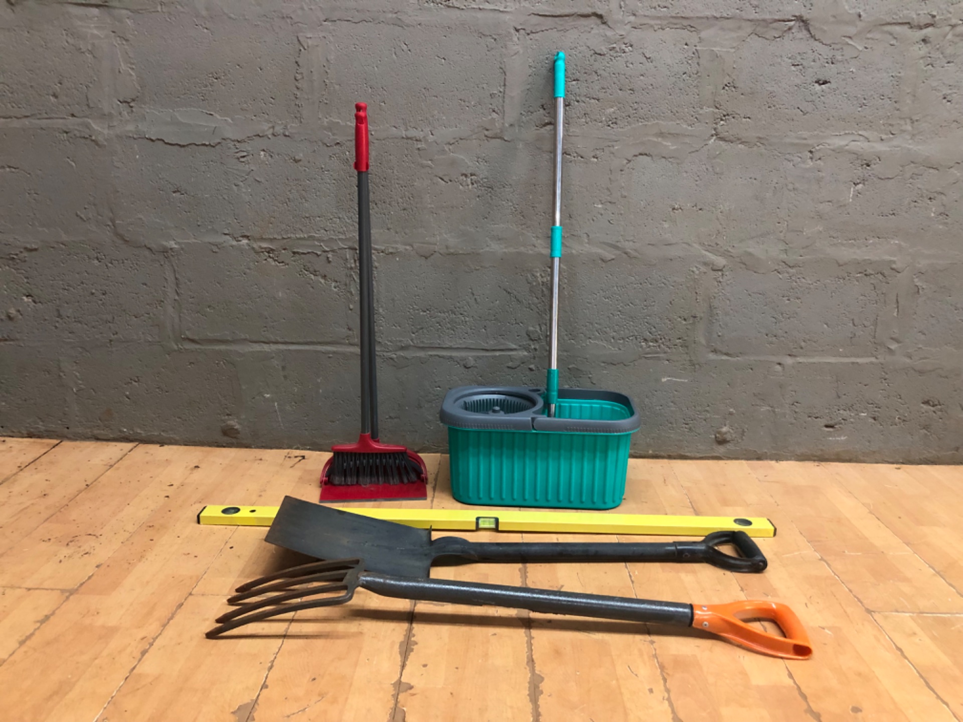 Mixed lot — Spin mop + bucket (wringer works), long-handled dustpan & broom, spirit level, shovel & 4‑tine garden fork — used, minor rust