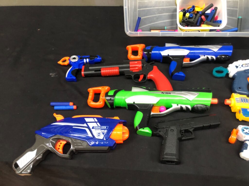 Assorted foam‑dart toy blaster lot with darts (9 items) — mixed colours, visible wear