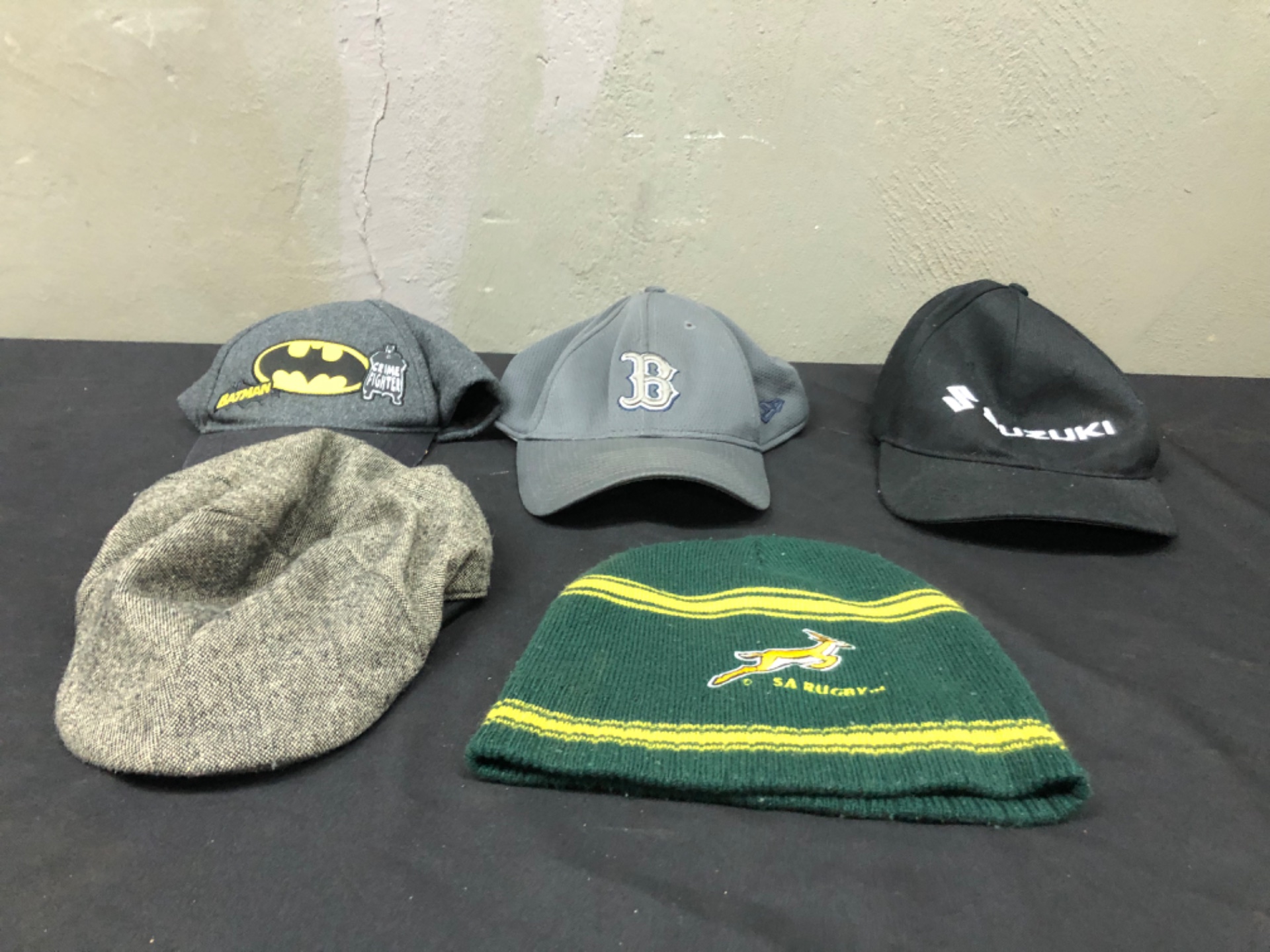 Mixed lot of 5 used caps & beanies — Batman patch, New Era 39THIRTY ‘B’ cap, Suzuki cap, SA Rugby beanie, grey flat cap