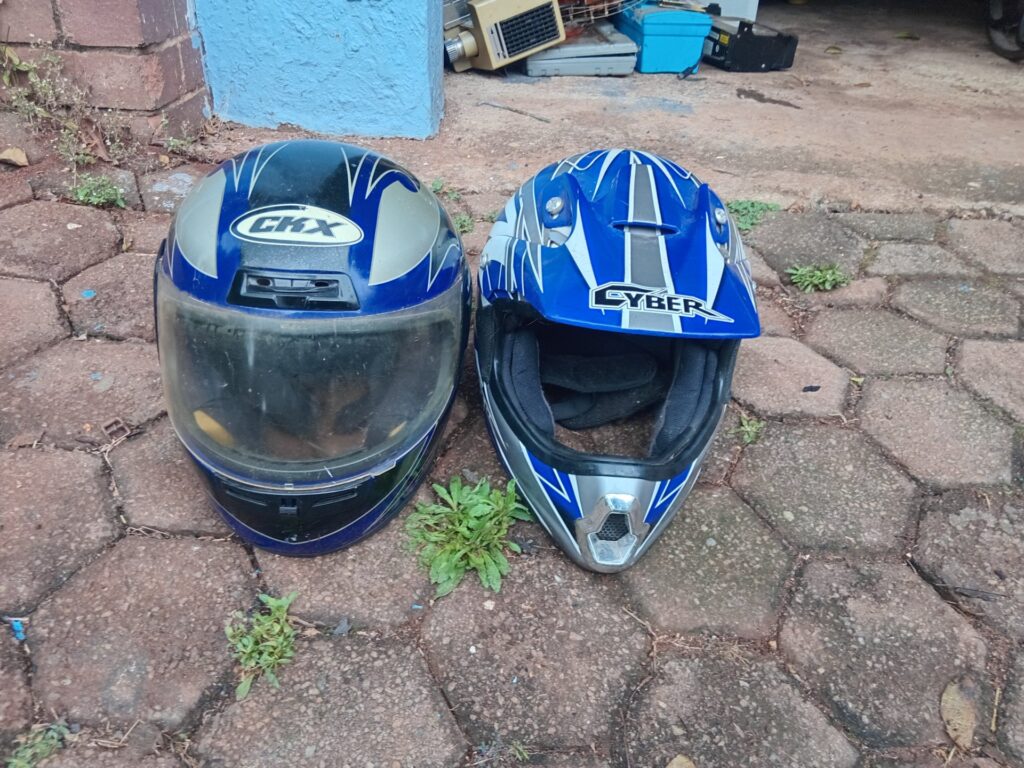 Pair of used motorcycle helmets — CKX full-face + Cyber off-road style, blue/grey graphics
