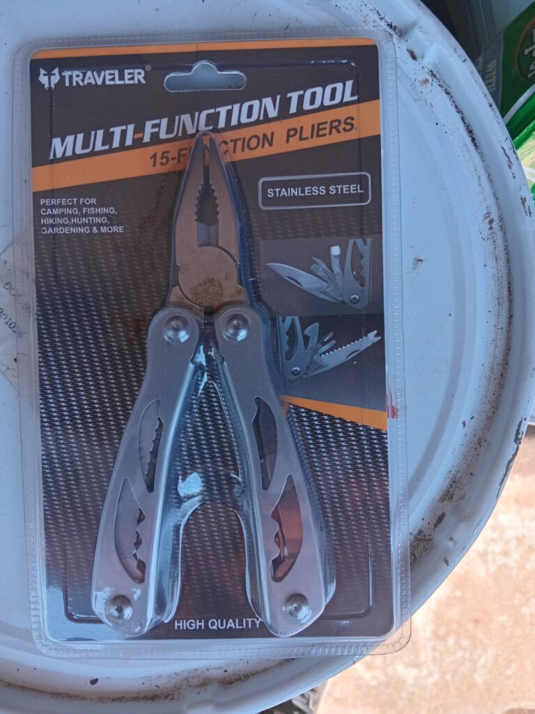 Traveler 15-Function Multi-Tool (sealed blister) with nylon belt pouch — surface stain on jaws