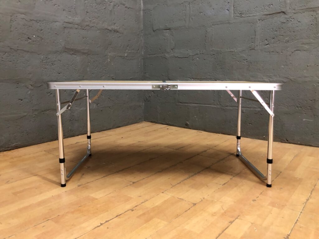 Portable folding aluminium camping table — wood‑effect top, adjustable legs, locks closed (122 x 60 x 55 cm)