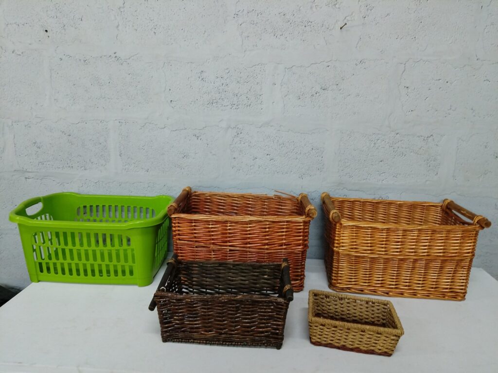 Mixed lot of 5 assorted baskets — wicker storage baskets + green plastic laundry basket, used with visible wear