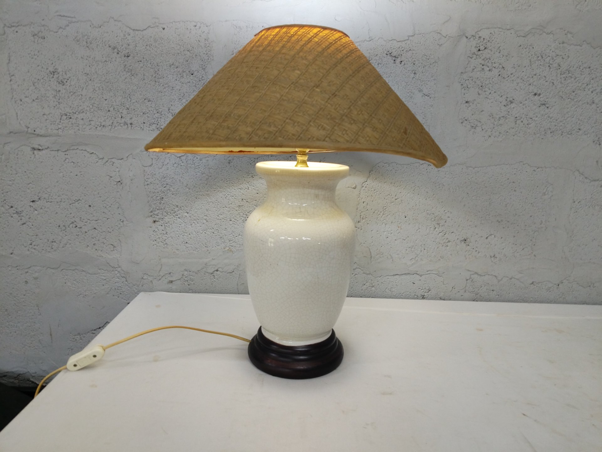 White glazed ceramic table lamp (crazed glaze) with woven cone shade on wooden plinth — tested working